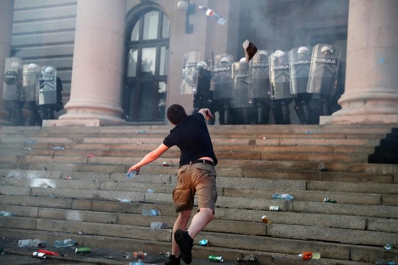A protestors throws a rock as demonstrators clash with police officers during an anti-government rally in front of the parliament building in Belgrade, Serbia. REUTERS/Marko Djurica    